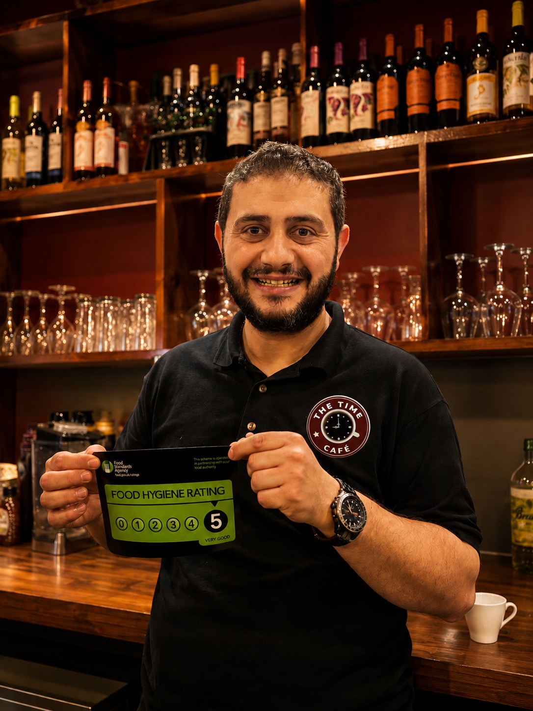 The Time Caf&eacute; team member holding a 5-star food hygiene rating certificate.